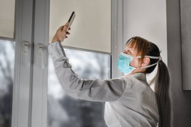 Kadın arkadaşlarını telefonla arar, evde kalır ve koronavirüsü, salgını durdurmak için kendini karantinaya alır. Sosyal mesafeyi koru.