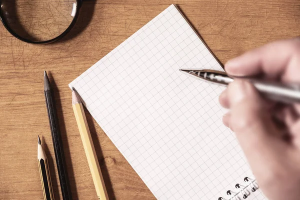 Visão Superior Mão Homem Escrevendo Papel Branco Lápis Lupa Mesa — Fotografia de Stock
