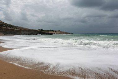 Rodos 'taki Ege Denizi' nin kumsalında dramatik yağmurlu gökyüzü ve fırtınalı dalgalar..