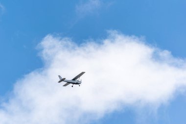 Tek piston gri uçağı. Tek pervaneli uçaklar mavi gökyüzünde beyaz bulutlara karşı uçuyor..