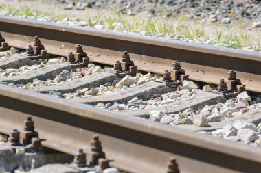 Çakıl taşları üzerinde demir paslı demiryolu detayı, sığ alan derinliği