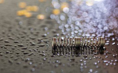 Metal yaylara yakın çekim. Makro resim. - Evet. Küçük mekanik elementler. Kalemin elementleri. Çelik parçaları. Siyah arka planda bahar. Hassasiyet mekaniği.