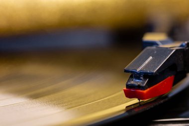 Vinil plaklı bir pikap. Nostaljik ekipmanlar. Retro müzik. Bir fonograf iğnesinin yakın çekimi. Gramofon kayıtlarındaki yansımalar.