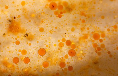 Tavada yağ lekeleri var. Farklı boyutlarda. Sarı sıvı. Kızarmadan sonra artanlar. Yukarıdan Macro fotoğrafı. Turuncu lekeler.