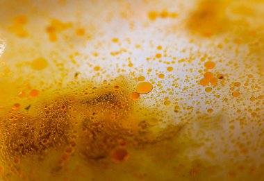 Tavada yağ lekeleri var. Farklı boyutlarda. Sarı sıvı. Kızarmadan sonra artanlar. Yukarıdan Macro fotoğrafı. Turuncu lekeler.