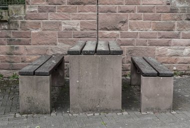 Şehir parkındaki banklar. Dinlenme ve dinlenme yeri. Eski tuğla ve taş duvar. Şehirde gezinti güvertesi. Bir bankta tahta basamaklar.