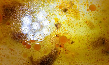 Tavada yağ lekeleri var. Farklı boyutlarda. Sarı sıvı. Kızarmadan sonra artanlar. Yukarıdan Macro fotoğrafı. Turuncu lekeler.