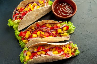 Siyah arka planda jambonlu ve sebzeli sandviç.