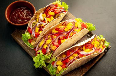 Siyah arka planda jambonlu ve sebzeli sandviç.