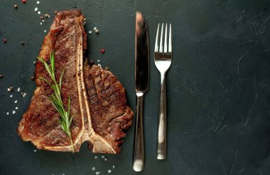 Arka planda ızgara biftek ve baharat.  