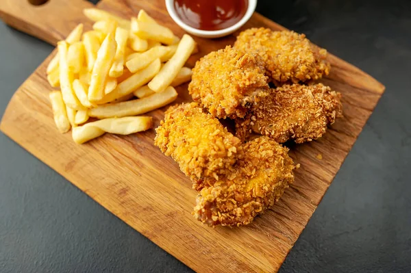 fried chicken and french fries on wooden background