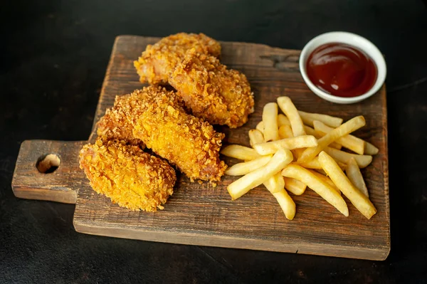 fried chicken and fries on a black background