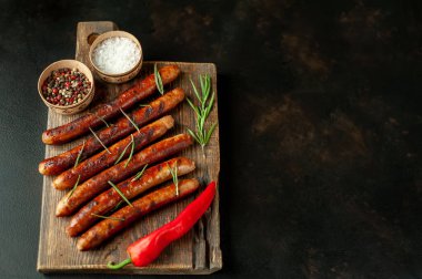 Tahtada baharatlı ızgara sosis.