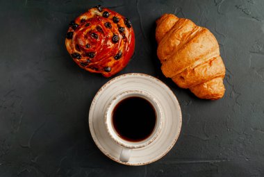 Koyu arkaplanda fırın ürünü olan kahve ve kahve.