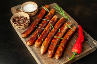 Tahtada baharatlı ızgara sosis.