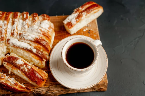 cup and coffee with bakery product on a dark background