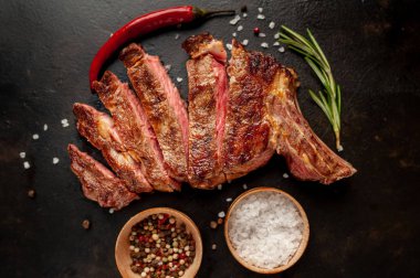 Siyah arka planda baharatlı biftek.