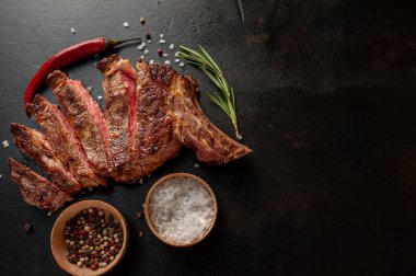 Siyah arka planda baharatlı biftek.