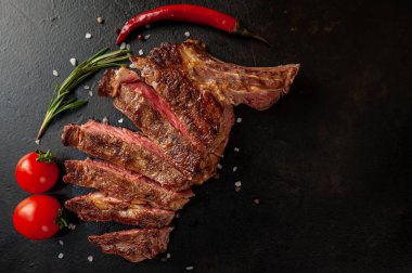 Siyah taş arka planda dilimlenmiş biftek.