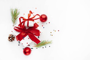 Parlak topları ve köknar dallarıyla beyaz ve kırmızı hediyeler.