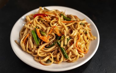 Siyah arka planda biberli makarna.