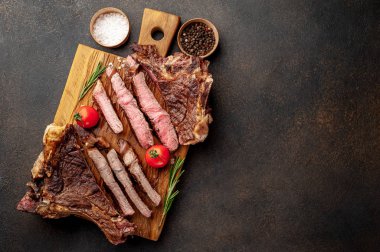 Tahtada domatesli dilimlenmiş biftek.