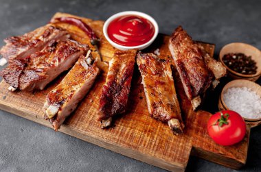 Izgara domuz pirzolası ve ahşap tahtada baharatlar.