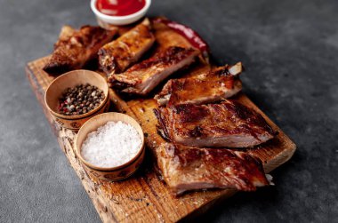 Izgara domuz pirzolası ve ahşap tahtada baharatlar.