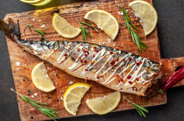 Tahtada servis edilen limonlu ve baharatlı fırında uskumru.