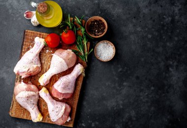 Çiğ tavuk bacağı, domates ve baharatla servis edilir.