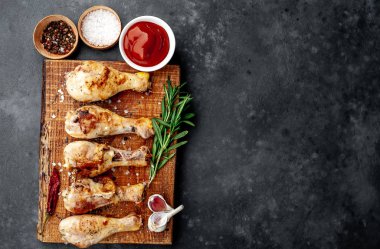 Kızarmış tavuk budu, bbq sosu ve ahşap tahtada biberiye.