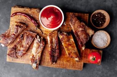 Izgara domuz pirzolası ve ahşap tahtada baharatlar.