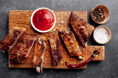 Izgara domuz pirzolası, bbq sosu ve ahşap tahtada baharatlar.