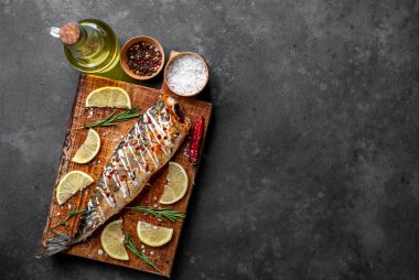 Tahtada servis edilen limonlu ve baharatlı fırında uskumru.