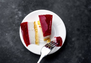 Beyaz tabakta çatalla servis edilen katmanlı pasta.