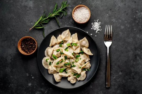 Leckere Knödel Auf Schwarzem Teller Serviert Mit Gewürzen Und Gabel — Stockfoto