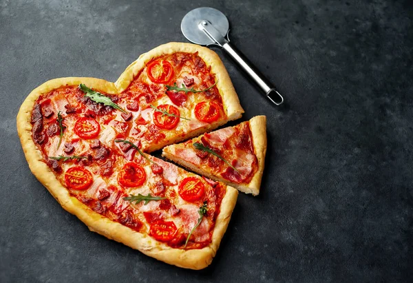 Heart shaped pizza with pizza cutter. Valentines day.