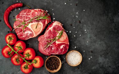 Domates ve baharatlı iki çiğ biftek. 