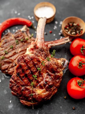 Baharatlı ızgara sığır baltasının yakın plan görüntüsü, arka planda kekik.