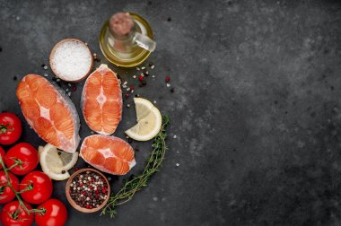 fresh raw salmon steaks on a stone background with salt, pepper, lemon with copy space for your text2