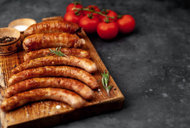 Various grilled sausages with spices on a stone table