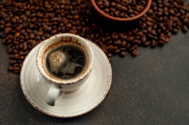 Angle  view of cup of tasty coffee and beans on a stone background. 