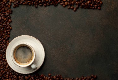 To view of cup of tasty coffee and beans on a stone background. 