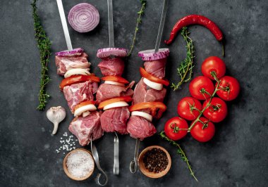 Taş zeminde çiğ et şişleri.