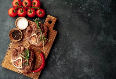 grilled steak, with tomatoes and spices on a stone background 