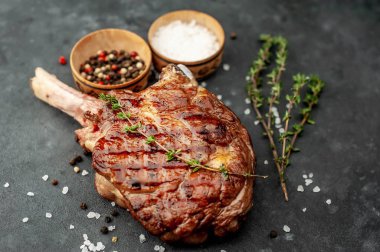 Baharatlı ızgara sığır baltası, kekik taştan bir arka planda.