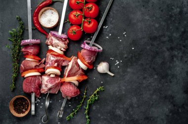 Taş zeminde çiğ et şişleri.