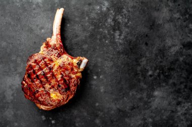 Baharatlı ızgara sığır baltası, kekik taştan bir arka planda.