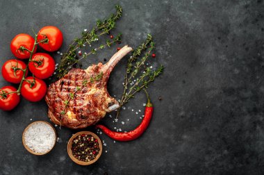 Bifteğin üst görüntüsü - Baharatlı ızgara dana baltası, taştan bir arka planda kekik