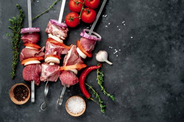 Taş zeminde çiğ et şişleri.